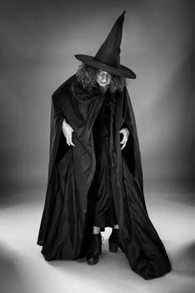 Старая Ведьма Черном Плаще Шляпе Сером Фоне — стоковое фото