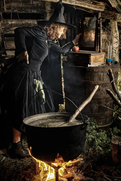 老巫婆在铸铁锅中为万圣节酿造致命药水 — 图库照片