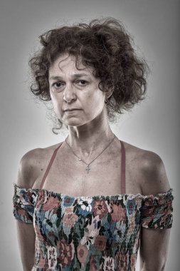 Gri arka plan üzerinde üzgün olgun bir kadın portresi stüdyo