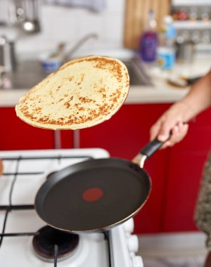 El becerisi ile kızartma tavasında pancake flipping kadın Closeup
