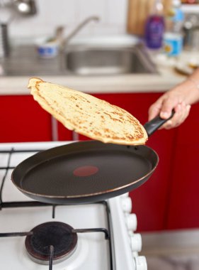 El becerisi ile kızartma tavasında pancake flipping kadın Closeup
