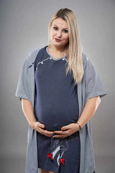穿着睡衣的年轻孕妇 灰色背景的工作室肖像 — 图库照片