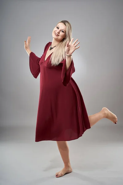 スタジオ全身ポートレートの妊娠中の女性で赤いドレス — ストック写真