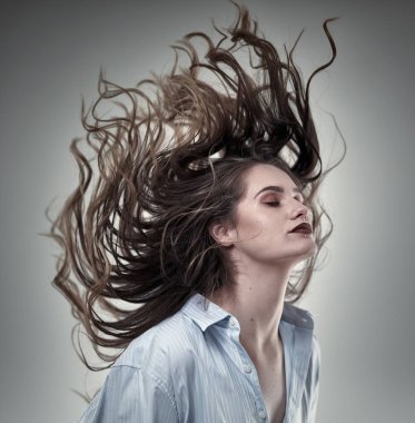 Genç, çekici, saçları uçuşan bir manken.