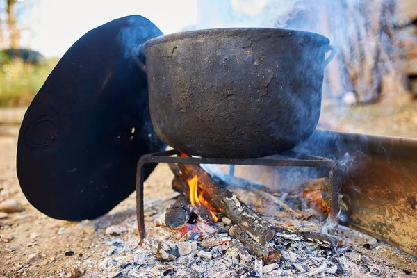 田舎の大きな鋳鉄鍋沸騰水屋外 — ストック写真