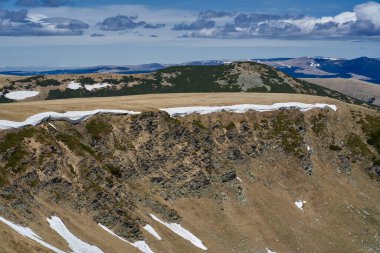 Yazın dağlarla kaplı manzara, hala kar parçaları var.