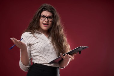 Gözlüklü ve panosu olan bir iş kadını, ne yapacağından emin değil.