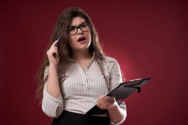 Gözlüklü ve panosu olan bir iş kadını, ne yapacağından emin değil.