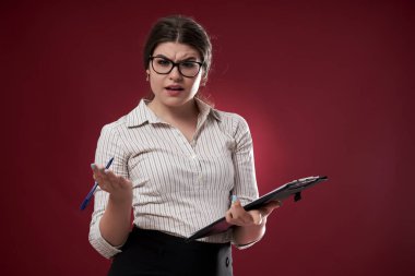 Gözlüklü ve panosu olan bir iş kadını, ne yapacağından emin değil.