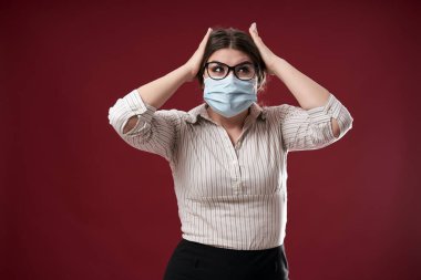 Aşırı stresli iş kadını başını tutuyor, maske takıyor.