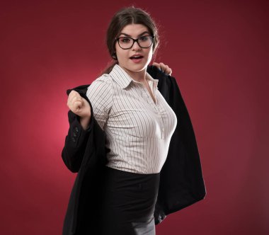 Kırmızı arka planda çekici bir iş kadınının yakın çekimi.