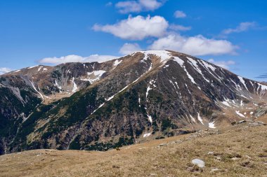 Yazın dağlarla kaplı manzara, hala kar parçaları var.