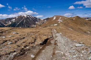 Yazın dağlarla kaplı manzara, hala kar parçaları var.