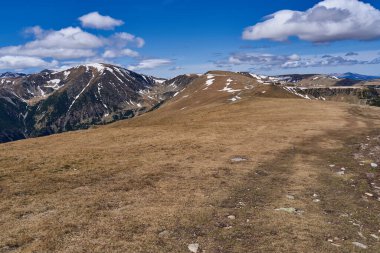 Yazın dağlarla kaplı manzara, hala kar parçaları var.