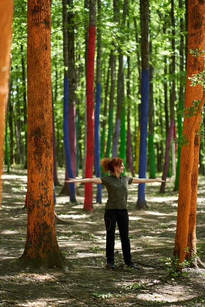 Renkli bir ormanda bir kadının tam boy portresi.
