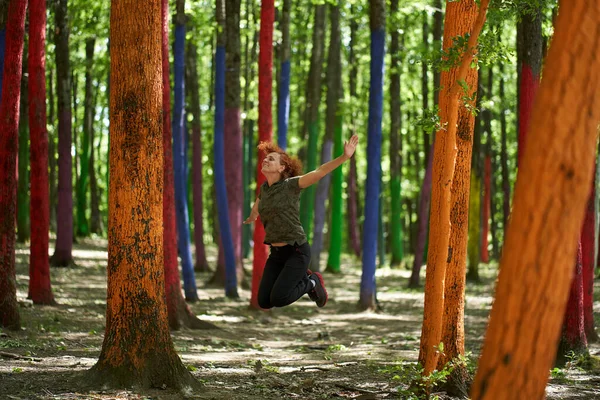 Renkli bir ormanda zevkten dört köşe olan bir kadın
