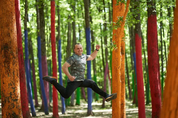 Blanke Man Springt Van Vreugde Een Bos Met Gekleurde Bomen — Stockfoto