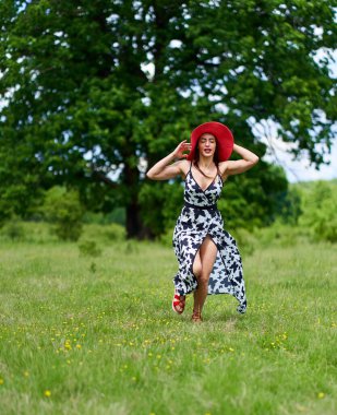Yazlık elbisesiyle bir meşe ormanında poz veren muhteşem güzellik mankeni.