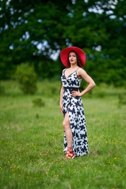 Yazlık elbisesiyle bir meşe ormanında poz veren muhteşem güzellik mankeni.