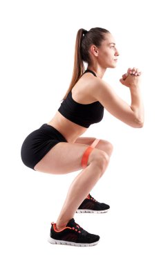 Beyaz arka planda izole edilmiş elastik bantlarla çalışan atletik kadın