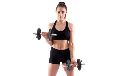 Genç İspanyol atletik kadın beyaz arka planda dambıllarla çalışıyor.