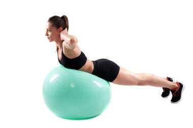 Spor salonundaki kız, spor salonundaki topla antrenman yapıyor.