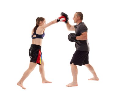 Kız kickboks dövüşçüsü koçuyla yumruk tokuşturuyor, beyaz arka planda izole edilmiş.