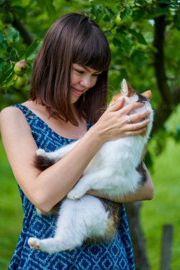 Norveçli evcil kedisiyle açık havada bir kız.