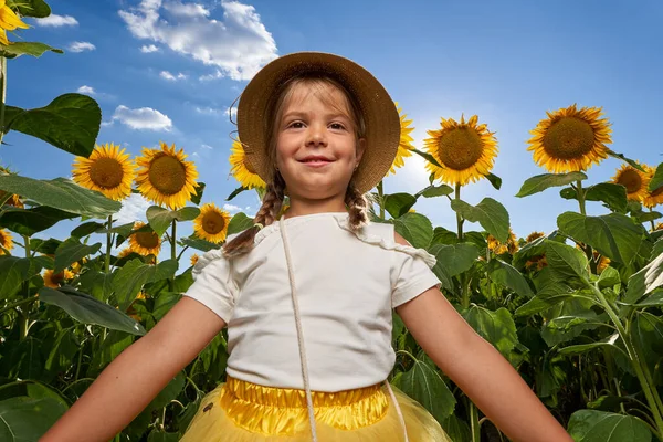 可愛いです女の子とともに農家の帽子でひまわり畑 — ストック写真