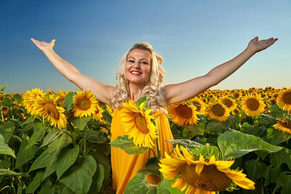 Beautiful blonde Caucasian woman in a sunflower field