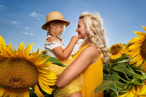 年轻的母亲和她可爱的女儿在向日葵地里玩得很开心 — 图库照片