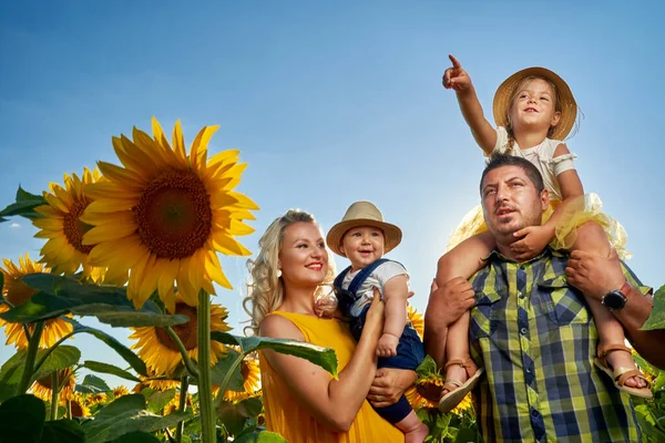 Ung Familj Med Två Barn Som Har Roligt Ett Solrosfält — Stockfoto