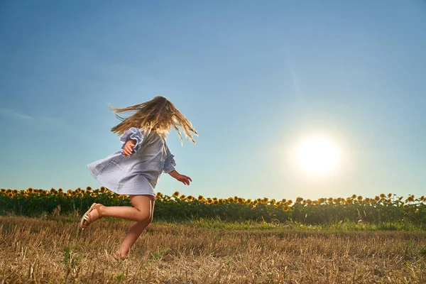 Lycklig Liten Flicka Dansar Framför Ett Solrosfält — Stockfoto