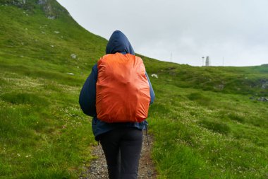 Sırt çantalı bir turist dağlarda yürüyüş yapıyor.