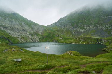 Sisin içindeki dağlarda buzul gölü olan bir manzara.