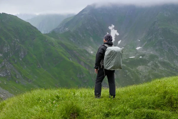 Turista Pláštěm Deště Velkým Batohem Horách — Stock fotografie