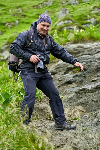 Turysta Płaszczem Przeciwdeszczowym Dużym Plecakiem Wędrujący Górach — Zdjęcie stockowe