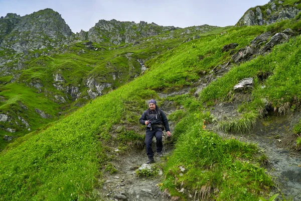 Turysta Płaszczem Przeciwdeszczowym Dużym Plecakiem Wędrujący Górach — Zdjęcie stockowe