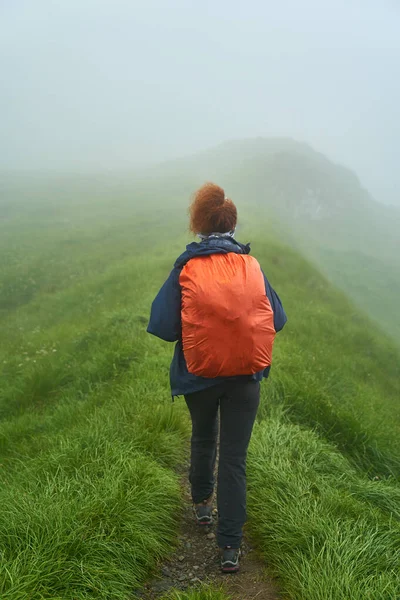 Sırt çantalı bir turist dağlarda yürüyüş yapıyor.