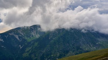Yaz mevsiminde yüksek dağlar ve bulutlarla dolu bir yaz günü.