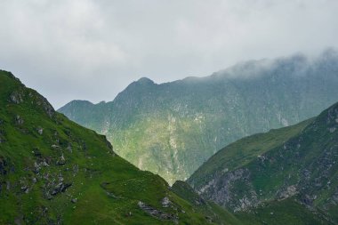 Yaz mevsiminde yüksek kayalık dağ zirveleriyle manzara