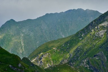 Yaz mevsiminde yüksek kayalık dağ zirveleriyle manzara