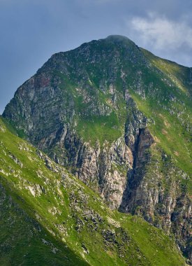 Yaz mevsiminde yüksek kayalık dağ zirveleriyle manzara