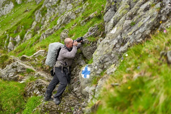 Profesjonalny Fotograf Przyrody Aparatem Fotograficznym Duży Plecak Wędrówki Górach — Zdjęcie stockowe