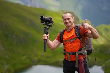 Profesyonel kameraman dağların tepesinde bir vibratörle çekim yapıyor.