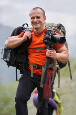 Profesyonel kameraman dağların tepesinde bir vibratörle çekim yapıyor.