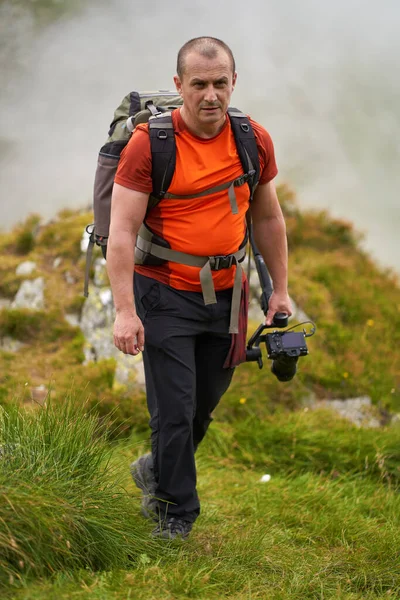 Profesyonel kameraman dağların tepesinde bir vibratörle çekim yapıyor.