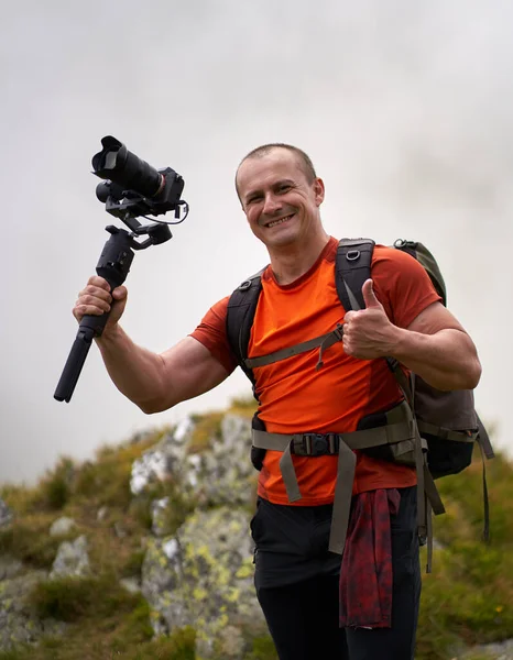 Vidéographe Professionnel Tirant Avec Une Carabine Haut Dans Les Montagnes Photo De Stock