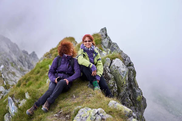 两个女游客朋友背着背包一起在山上远足 — 图库照片