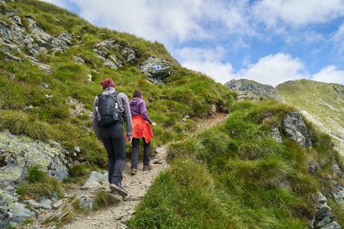 Dağlarda bir patikada iki genç yürüyüşçü